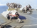 Shipboard aircraft tugs moving a TBM-1C Avenger torpedo bomber and F6F Hellcat fighters aboard the Fleet Carrier USS Lexington (Essex-class), 1945.