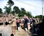 US Army troops drive by the people of Montebourg, Normandy, France, June 1944.  Note M2 Half-Track “Dirty Gertie” and M4 Sherman Duplex-Drive tank with soldiers sitting on the folded skirt frame.