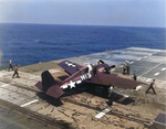 Crews check on pilot Ens John E Hood in his FM-2 Wildcat after a hard landing aboard training aircraft carrier USS Sable on Lake Michigan, United States, 1945.  Note bent propeller blades.