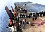 Crews move quickly to secure an F6F Hellcat as it hangs over the side of the training aircraft carrier USS Sable on Lake Michigan, United States, 1945.