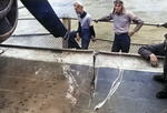 The flight deck of the training aircraft carrier USS Sable showing a severe slice in the steel caused by the spinning propeller of an F6F Hellcat. Lake Michigan, United States, 1945.