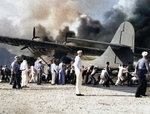 Air Station personnel move a damaged PBY Catalina away from burning hangars at Kaneohe Naval Air Station, Oahu, Hawaii, Dec 7, 1941.