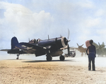 F4U-1 Corsair of Marine Squadron VMF-114 set for take-off from Peleliu, late 1944. Note C-46 Commando.