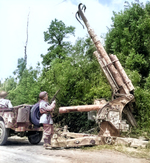 US Army patrol examining a German 88 mm FlaK anti-aircraft gun with its barrel splayed by the retreating Germans near Montebourg, France, June 1944