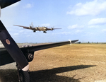 A Boeing B-29 Superfortress of the 9th Bomb Group comes in for a landing on Iwo Jima, Mar 10, 1945. Note P-51D Mustang in the foreground.