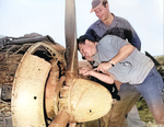 Souvenir hunters on Iwo Jima sawing the propeller off of a wrecked Japanese Nakajima Ki-43 "Oscar" fighter, Mar 1945. They said they would make paper weights out of it later.