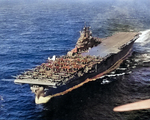 USS Intrepid under way 26 Jan 1944 on her way to launch strikes against Truk Atoll (now Chuuk). Note the forward flight deck filled SBD Dauntless and TBF Avenger aircraft and one F4U Corsair on the outrigger sponson.