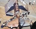 Overhead view of plane handlers spotting an SB2C Helldiver aboard USS Bennington, early 1945. This view offers a good look at the large surface area of the Helldiver’s tail plane.