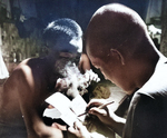 Japanese prisoner of war practicing English writing while a fellow prisoner looked on, Guam, Aug-Sep 1945