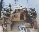 The helm of PT-295, a Higgins 78-foot motor torpedo boat, 1944. Note the mast in the lowered position, two twin Browning .50 caliber machine gun mounts, and a 20mm Oerlikon gun forward.