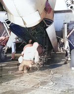 US Navy ordinancemen loading a Mark XIII torpedo into the bomb bay of a TBM Avenger aboard USS Lexington (Essex-class) while steaming south of Hawaii, 12 Sep 1943. Note the hand operated winches lifting the torpedo.