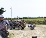 A Jeep full of US 101st Airborne paratroopers at a Normandy check-point, Jun 1944. Note Horsa gliders in the background and a box of full M1 Garand ammunition clips in the immediate foreground behind the MP’s leg.