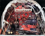 Close-up view of a P-38G Lightning aircraft cockpit, 23 Dec 1942; note the yoke rather than stick control and the bullet proof glass panel above the instrument panel. Photo 2 of 3.