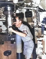 An officer aboard the submarine USS Bullhead looking through the aft periscope, about May 1945, location unknown.