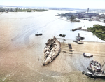 The battleship USS Oklahoma, capsized in the Pearl Harbor Attack on 7 Dec 1941, is righted to about 30-degrees during her salvage work, 29 Mar 1943. Photo 2 of 2.