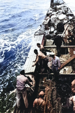 US Navy salvage team removes a damaged torpedo from its stowage position on the deck of the Captured German submarine U-505 before jettisoning the torpedo over the side, eastern Atlantic, 9 June 1944.