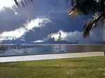 USS Nevada, down by the head, beached at Hospital Point in Pearl Harbor, Hawaii during the Japanese air attack on 7 Dec 1941. Note smoke from destroyer USS Shaw in the floating drydock just beyond Nevada.