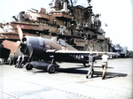 Crewmen beginning to fold the wings of a Grumman F6F-5 Hellcat of Air Group 87 immediately after landing aboard USS Ticonderoga, Apr-May 1945 in the central Pacific.