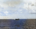 As seen from USS Sangamon off Surigao Island, Philippines, 26 Oct 1944, escort Carrier USS Suwannee recovering aircraft. Note the TBM-1C Avenger lining up to land on the carrier and A6M Zero diving on the ship.