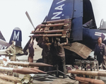 Armorers equipping a F4U-4B Corsair fighter of US Navy squadron VF-64 with Ram and HVAR rockets aboard USS Philippine Sea, off Korea, 21 May 1951