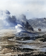 F4U-4 Corsair fighter of US 1st Marine Air Wing in flight over a contested battlefield, Korea, 1 Oct 1952