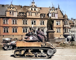 US Army African-American crew of the 761st Tank Battalion on a M5A1 Stuart light tank in Coburg, Bayreuth, Germany, 25 Apr 1945. Note white flags hanging from upper palace windows. Also note evidence that those windows have been machine gunned.