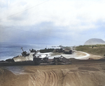 An American bulldozer pulled a road grader on an Iwo Jima beach, 21 Apr 1945, note several Japanese landing ships wrecked on the coast beyond the road