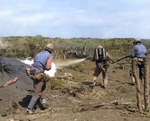 A US Marine used a flamethrower against a Japanese pillbox as he was covered by two riflemen, Iwo Jima, Feb 1945