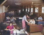 Virginia Shilby (foreground left), John Tucker (center), and other workers at the Housing Department office of Jerome War Relocation Center, Arkansas, United States, 17 Nov 1942