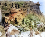 German prisoners being taken away atop a cliff at Pointe du Hoc, Normandy, France, 8 Jun 1944; note American flag draped on cliff wall to prevent friendly fire