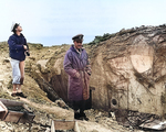 US Navy Lieutenant Commander Knapper and Chief Yeoman Cook of USS Texas examining a damaged German pillbox at Pointe du Hoc, Normandy, France, 6 Jun 1944; note covered dead US Army Ranger at right