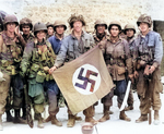 Paratrooper of US 101st Airborne Division holding a Nazi German flag captured in a village near Utah Beach, Saint-Marcouf, France, 8 Jun 1944