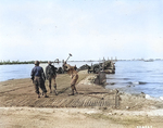 American soldiers constructing a landing ramp as part of the Mulberry A artificial harbor at Omaha Beach, Normandy, circa mid-Jun 1944