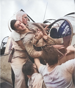 Gunner Kenneth Bratton, wounded in the knee by shrapnel, being pulled out of the turret of a TBF Avenger aircraft aboard USS Saratoga after a successful raid on Rabaul, New Britain, 5 Nov 1943