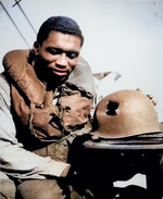 African-American US Coast Guardsman Fireman 1st Class Charles Tyner displaying his helmet, damaged by large shrapnel during the invasion of Southern France, circa late 1944