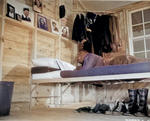 An African-American air cadet looking up at his collection of photos of his girl friends while he was studying on his cot, date unknown