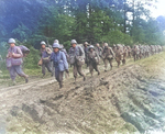 Japanese-American infantrymen of US 442nd Regimental Combat Team hike up a muddy French road in the Chambois Sector, France, late 1944