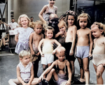 US Navy African-American cook Pendleton Thompson posed with children recently freed from a Japanese internment camp in the Philippine Islands aboard the SS Jean Lafitte en route for the US, Apr 1945