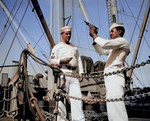 US Navy African-American Coxswain William Green checked his pistol while Quartermaster 1st Class Albert S. Herbert stood by with clip of ammunition and a holster belt, date unknown