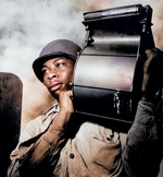 US Navy African-American Miles Davis King carrying a loaded magazine for a 20-mm gun aboard CVE USS Tulagi en route to France, Aug 1944