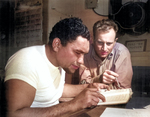 African-American US Merchant Marine Boatswain Maxie Weisbarth learning navigation from Chief Mate Earl Stanfield aboard a Victory Ship, Pacific Ocean, date unknown