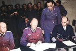 German Colonel General Alfred Jodl (center) signing the surrender document at Dwight Eisenhower