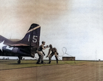 John Arledge and Theodore Schmidts unhooking a F4F fighter from the arresting cable aboard USS Anzio, Pacific Ocean, 21 Apr 1945