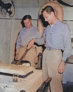 Lieutenant F. B. Underman (cutting cake) and Commander E. W. Davis celebrating the 5,000th landing aboard USS Anzio, 16 Apr 1945