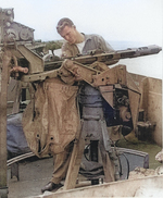 Seaman 1st Class Frank Stanley cleaning a 20mm gun aboard USS Anzio, 19 Apr 1945