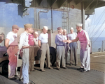 Captain George C. Montgomery shaking hands with men under his command aboard USS Anzio, 23 May 1945