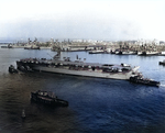 French aircraft carrier Bois Belleau moving to Norfolk Naval Base, Virginia, United States for aircraft loading, Dec 1953; note New Jersey, Albany, and Casa Grande in background