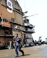 Seaman Leroy Kellam of Essex carried belts of 20mm ammunition for a F2H Banshee fighter aircraft, off Korea, 12 Oct 1951