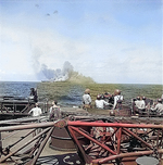 Intrepid smoking after being hit by Japanese special attack aircraft, seen from battleship New Jersey, 25 Nov 1944; note New Jersey