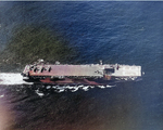 Aerial view of USS Makin Island off Leyte, Philippine Islands, 18 Nov 1944; note lowered forward elevator and FM-2 Wildcat aircraft on the flight deck